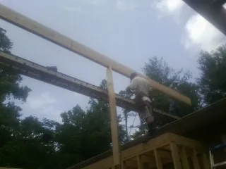 Carpenter setting a ridge beam over a new addition frame — Ice Dam Removal by Roofing Brothers in Coal Valley