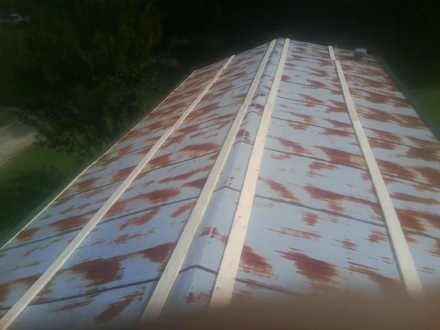 Rusted metal roof panels with new wood purlins before replacement — Storm Damage Roof Repair in Coal Valley by Roofing Brothers