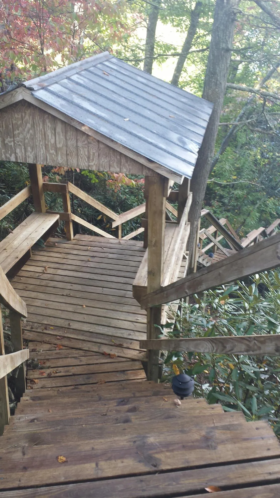 Metal roofed shelter over wooden steps on a wooded walkway — Skylight Repair & Installation work by our crew in Coal Valley