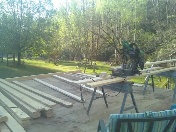 Miter saw and framing lumber on a deck under construction in Coal Valley