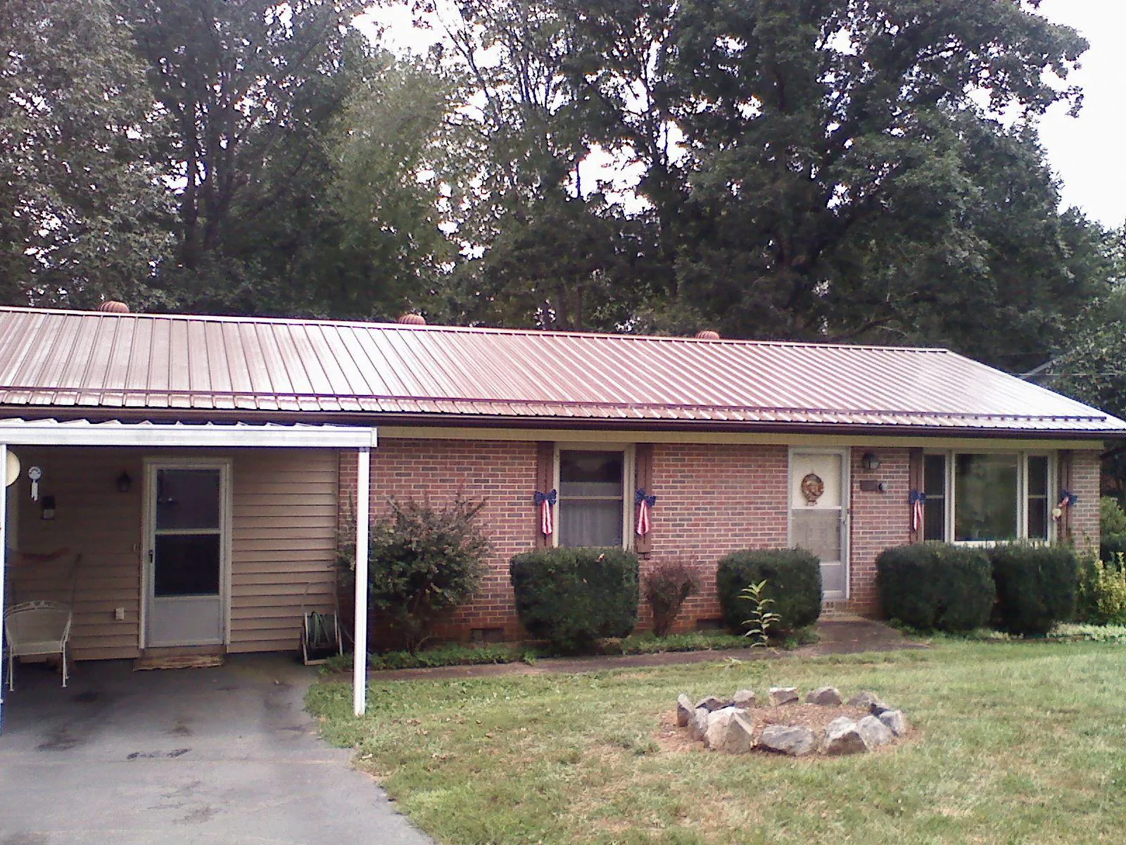 Bronze metal roof and carport on a brick ranch home — Roof Repair work by our crew in Coal Valley